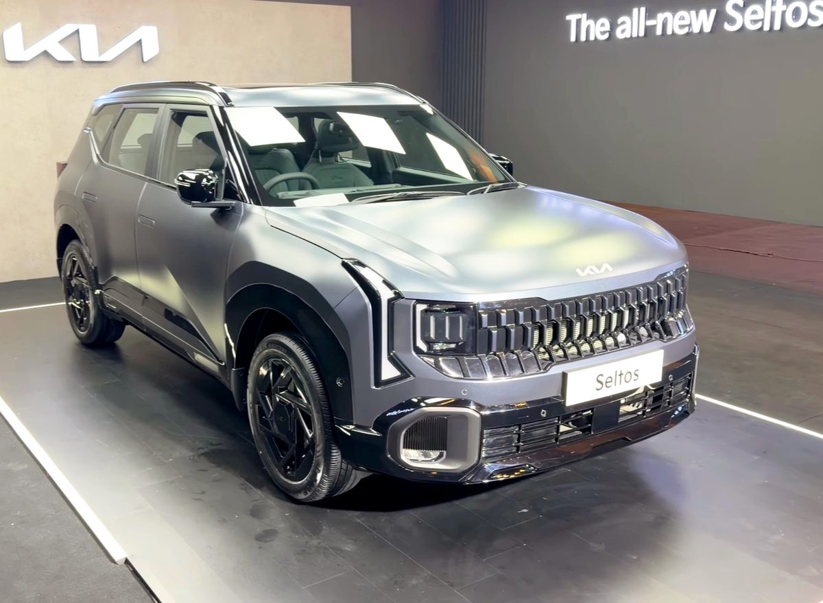 Kia Seltos in silver-grey on a display stand, front three-quarter view