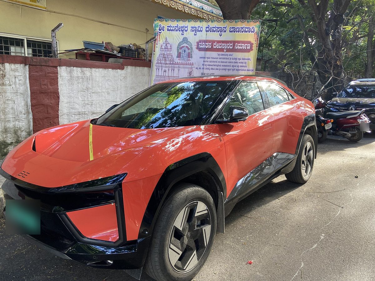 Mahindra BE 6 in orange parked on a street in Bengaluru, front three-quarter view
