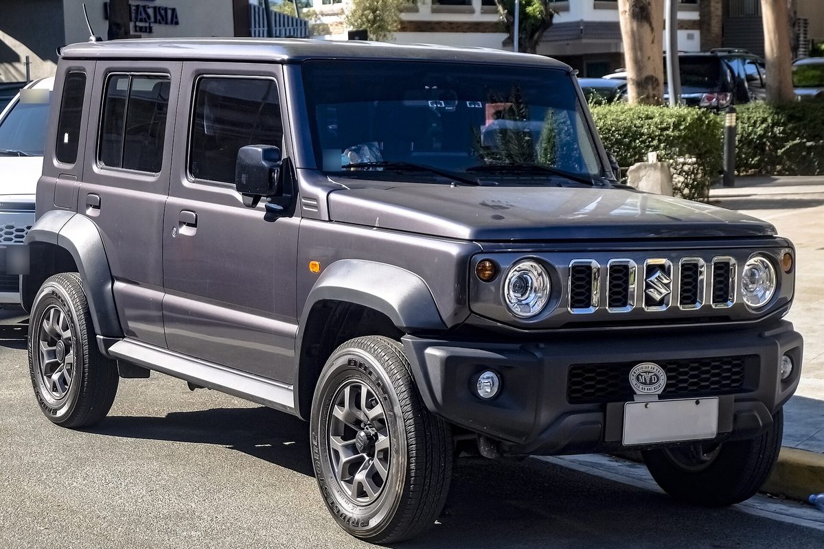 Suzuki Jimny five-door in grey parked on a street in the Philippines, front three-quarter view