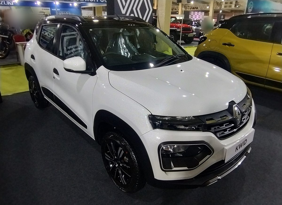 Renault Kwid in white with a black roof at an auto show, front three-quarter view