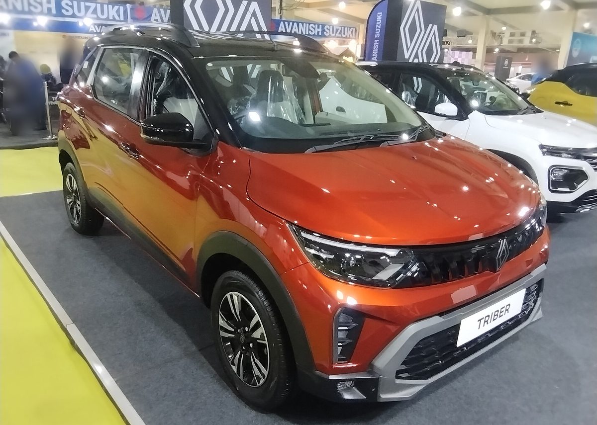 Renault Triber in orange with a black roof at an auto show, front three-quarter view