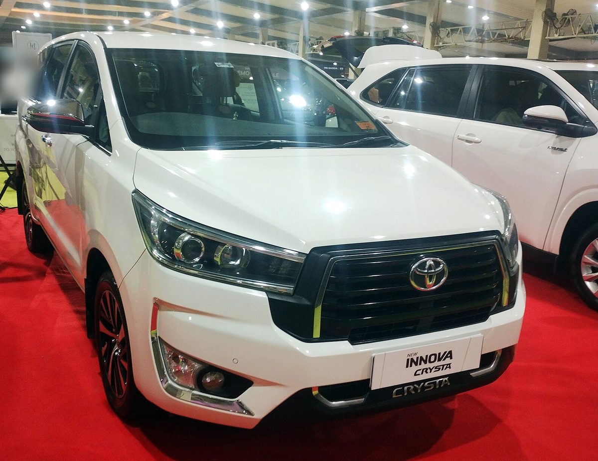 Toyota Innova Crysta in white at an auto show, front three-quarter view