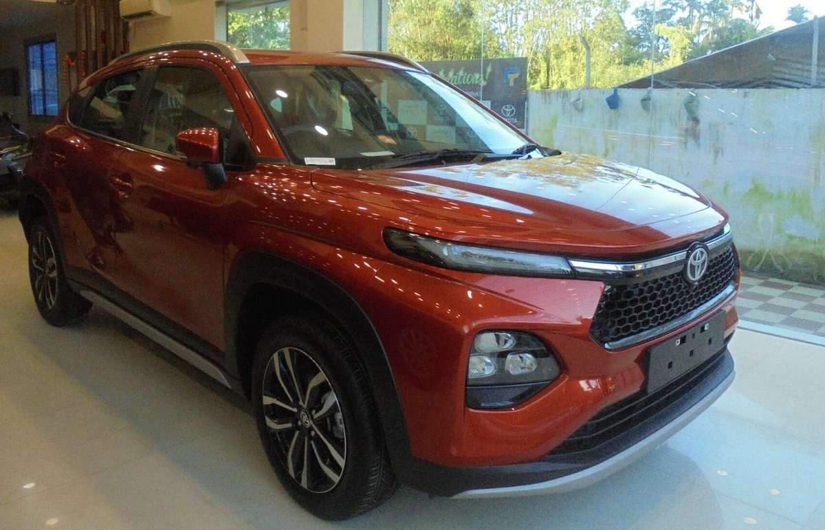Toyota Urban Cruiser Taisor in red in a showroom, front three-quarter view